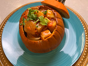 Pumpkin and Chicken Stew, a healthy fall meal served in a pumpkin for Halloween.