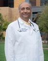 uci health physician alpesh amin, co leader of the uci diabetes iniative, wearing a white coat and stethoscope standing in front of uci medical center in orange